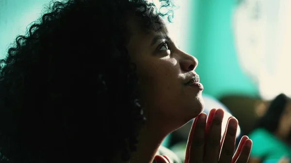 Afrikalı Amerikalı kadın Tanrı 'ya dua ediyor. Ruhsal siyah İspanyol bir kız dua ediyor Umutla ve inançla