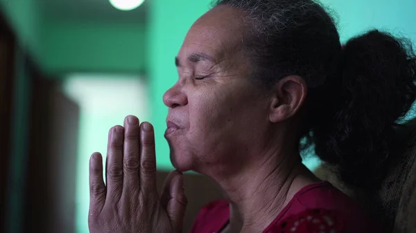 One hopeful senior woman praying to God at home. Spiritual person having FAITH