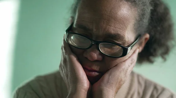 Pensive hispanic older woman closeup face with sad expression. Preoccupied South American senior lady in contemplation. Person in dilemma