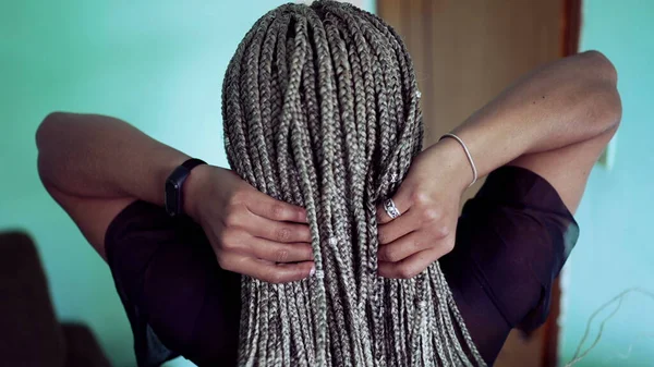 One young latina woman showing her braided hairstyle. Girl shows her box braids hair2