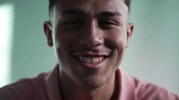 幸せなヒスパニック系の若者が顔を閉じている 南米系ブラジル人男性がカメラを見て室内で微笑む姿 — ストック写真
