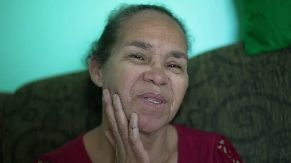 One thoughtful hispanic older woman closeup face. A pensive South American latin senior elder person