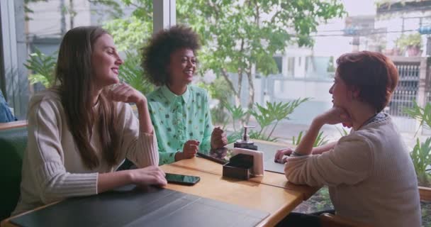 Τρεις Χαρούμενες Διαφορετικές Γυναίκες Που Κάθονται Στο Τραπεζάκι Της Καφετέριας — Αρχείο Βίντεο