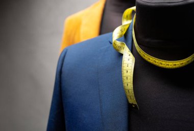 Terzi mankeni ve mezura üzerindeki takım elbise ceketi. Giysi mağazası iş yeri kavramı