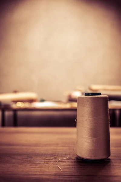 Masada dikiş aletleri olan iplik makarası. Giysi mağazası iş yeri kavramı