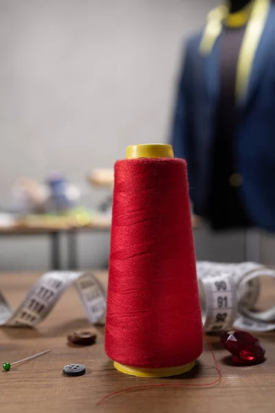 Masada dikiş aletleri olan iplik makarası ve iğne. Giysi mağazası iş yeri kavramı