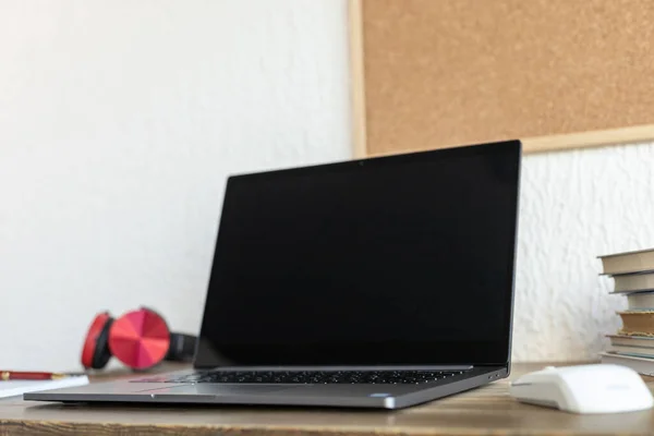 Ofisteki masada dizüstü bilgisayar ve defter var. Çevrimiçi öğrenim için çalışma yeri