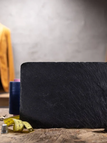 Tahta masada isim levhası ve dikiş aletleri. Giysi mağazası iş yeri kavramı