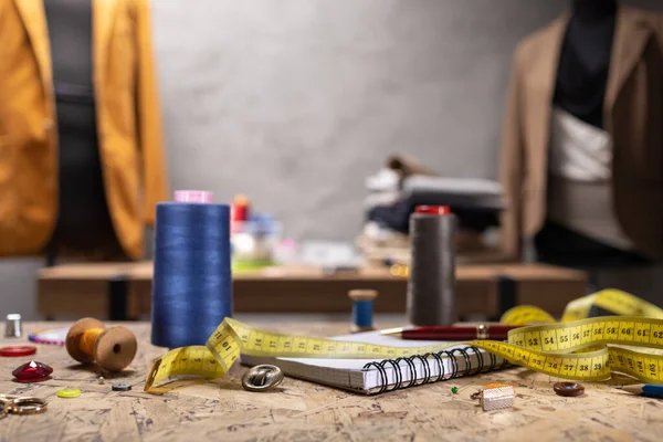 Terzi mankeni üzerinde dikiş aletleri ve terzi ceketi. Giysi mağazası iş yeri kavramı