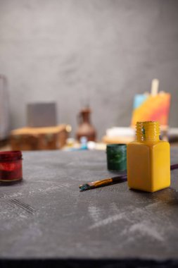 Soyut kedi masasında boya fırçası ve şişe. Boya fırçası ve resim ressamı aletleri masa arkası dokusunda. Sanatçı işyerinde resim yapmak