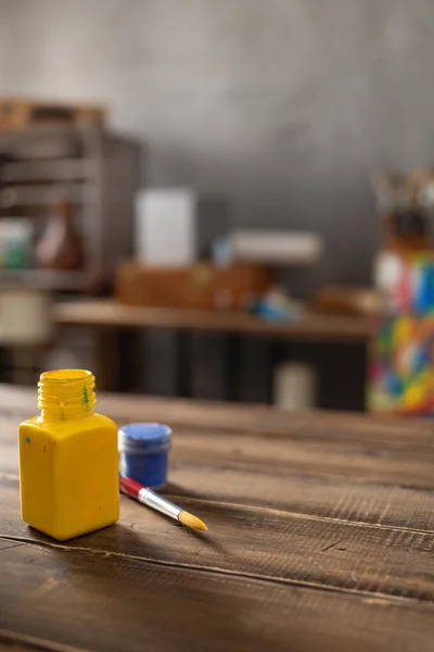 Ahşap masada boya fırçası ve şişe. Boya fırçası ve resim ressamı aletleri masa arkası dokusunda. Sanatçı işyerinde resim yapmak