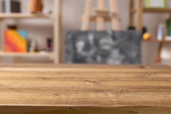 Boş ahşap masa ve sanatçı aletlerinin ön görüntüsü. Resim fırçası ve resim malzemeleri masa arkası dokusunda. Sanatçı işyerinde resim yapmak