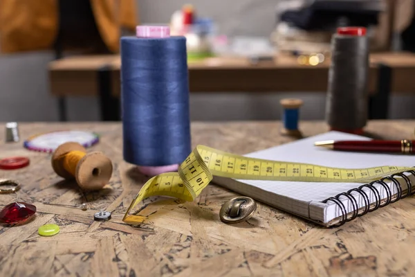 Masada dikiş aletleri olan iplik makarası. Giysi mağazası iş yeri kavramı