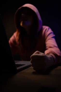 Bilgisayar laptopunun önünde bir hacker var. Karanlık oda geçmişindeki kadın hacker.