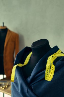 Terzi mankeni ve mezura üzerindeki kumaş. Giysi mağazası iş yeri kavramı