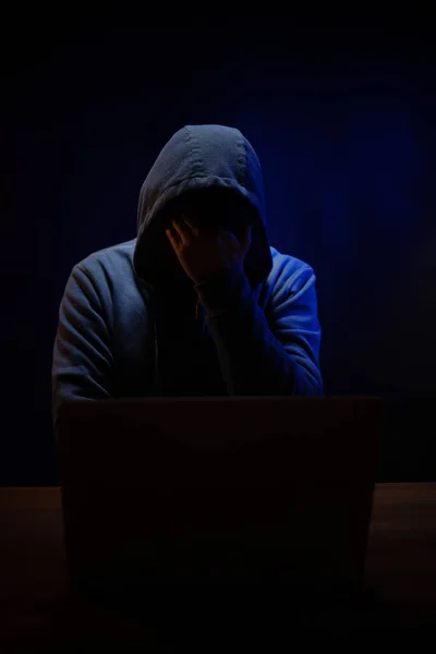 コンピュータのラップトップの近くのハッカー 暗い部屋の背景に男ハッカー — ストック写真
