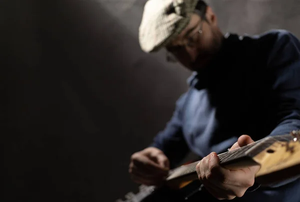 Man holding electric guitar. Musician in studio with electric guitar near wall