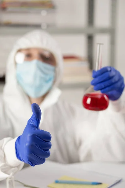 Bilim adamı sıvı reaktörlü test tüpü tutuyor. Doktor ve kimya laboratuarı cam eşyalar.