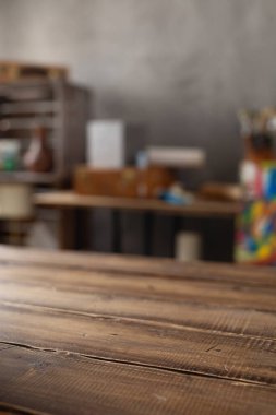 Boş ahşap masa ve sanatçı aletlerinin ön görüntüsü. Resim fırçası ve resim malzemeleri masa arkası dokusunda. Sanatçı işyerinde resim yapmak