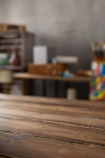 Boş ahşap masa ve sanatçı aletlerinin ön görüntüsü. Resim fırçası ve resim malzemeleri masa arkası dokusunda. Sanatçı işyerinde resim yapmak