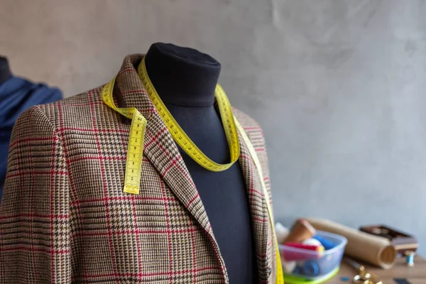 Terzi mankeni ve dikiş aletlerinde takım elbise ceketi. Giysi mağazası iş yeri kavramı