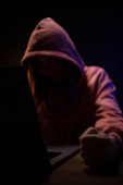 Hackerka pracující na notebooku. Hacker útok v pozadí tmavé místnosti