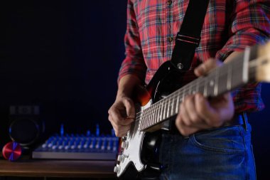 Elektro gitar çalan adam. Müzik stüdyosundaki müzisyen elektro gitar tutuyor.