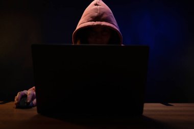 Bilgisayarda çalışan bilgisayar korsanı kadın. Karanlık oda arka planında Hacker saldırısı