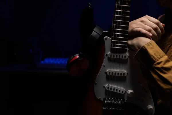 Man playing electric guitar. Musician in record studio holding electric guitar