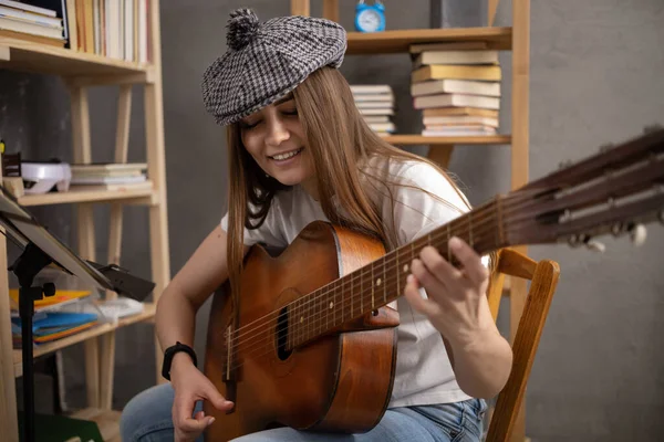 Akustik gitar çalan bir kız. Klasik akustik gitarlı müzisyen kadın stüdyoda.