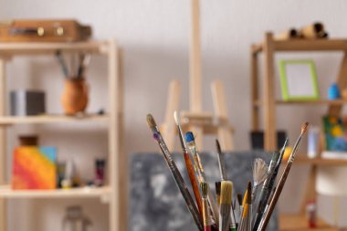 Ahşap arka planda boya fırçası ve resim boyama aletleri. Ressam stüdyosunda resim yapmak için boya fırçası