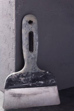 Soyut çimento arkaplan dokusunda macun bıçağı ve beton küp. Evin duvar köşesi.