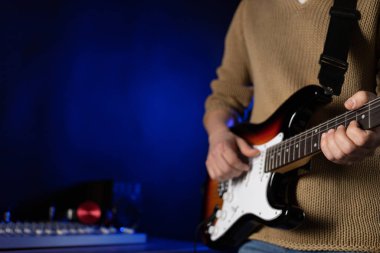 Elektro gitar çalan adam. Müzik stüdyosundaki müzisyen elektro gitar tutuyor.