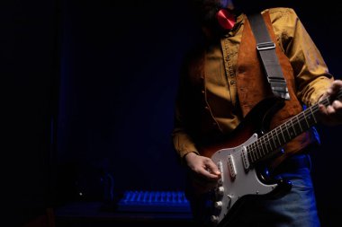 Elektro gitar çalan adam. Müzik stüdyosundaki müzisyen elektro gitar tutuyor.