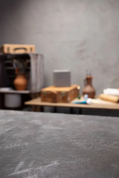 Boş tablo ve sanatçı araçlarının ön görünümü. Resim fırçası ve resim malzemeleri masa arkası dokusunda. Sanatçı işyerinde resim yapmak