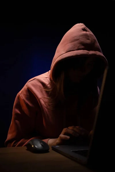 Hacker woman working laptop computer. Hacker attack in dark room background