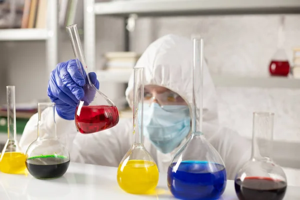 Bilim adamı sıvı reaktörlü test tüpü tutuyor. Laboratuvar bilimcisi ve kimya laboratuarı cam eşyalar.