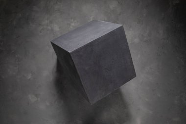 Concrete cube at abstract cement floor background texture. Geometric model concept