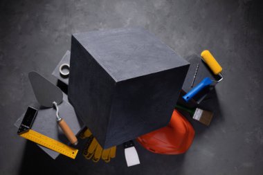 Cement cube and construction block at cement floor. Tool and construction concept on concrete background