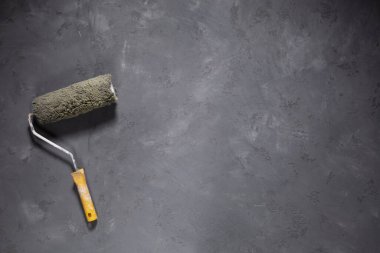 Paint roller at cement floor. Tool construction concept on concrete background