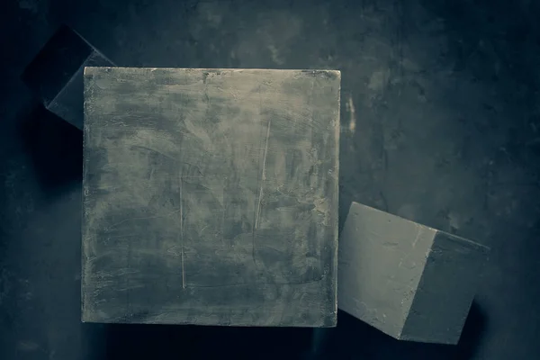 Concrete cube at abstract cement floor background texture. Geometric model concept