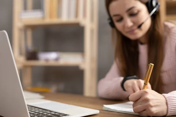 Girl listen headphones and writing at notebook. Student woman online larning. Creative inspiration study concept