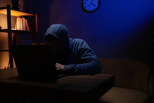 Hacker man working laptop computer. Hacker attack in dark room background