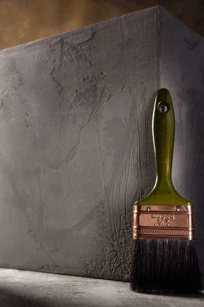 Soyut çimento arkaplan dokusunda boya fırçası ve beton küp. Evin duvar köşesi.