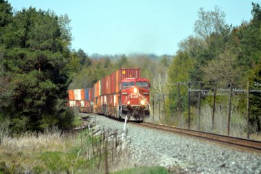 Fully loaded locomotive approaching under blue sky