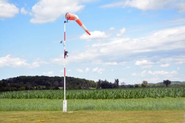 Hava alanında mavi bulutlu gökyüzüne karşı rüzgâr sock direkte