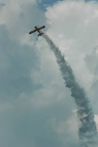 曇り空に対する煙の後に急上昇中のアクロバティックな航空機 — ストック写真