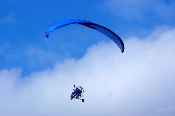 青い空と雲に対する飛行中のパラグライダー — ストック写真
