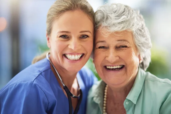 Portrait of a smiling nurse with her senior patient in a hospital — Fotografia de Stock