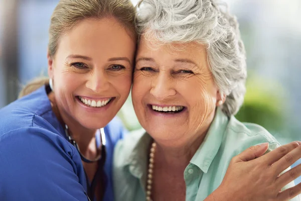 Portrait of a smiling nurse with her senior patient in a hospital — Fotografia de Stock